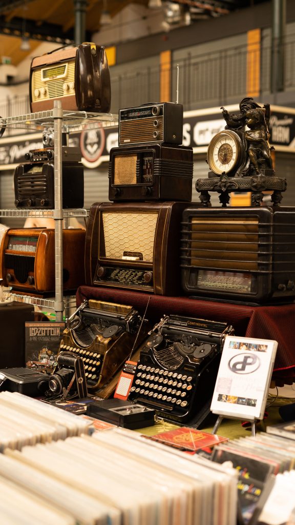 Programas RCN A collection of vintage radios and typewriters on display at a Budapest market.
